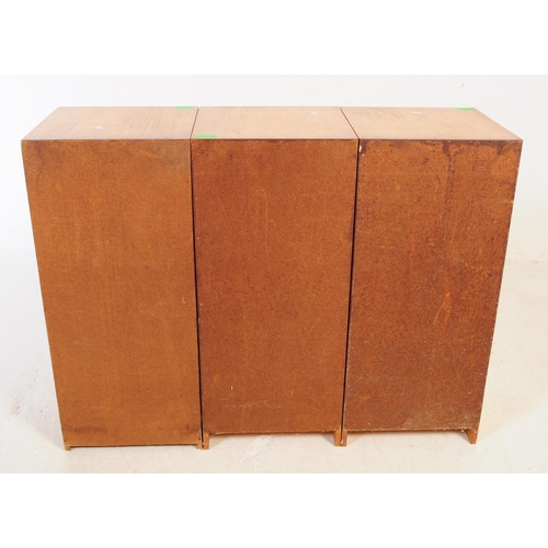 634 - A collection of three mid 20th century plywood bedside table / cupboards. The bedsides each featurin... 