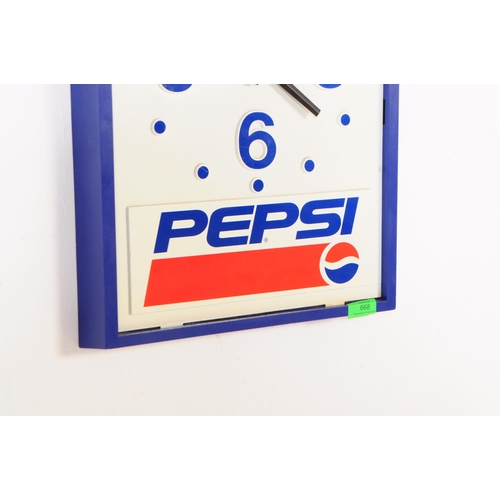 668 - Pepsi - A mid 20th century Pepsi branded plastic wall clock. The clock of rectangular form with blue... 