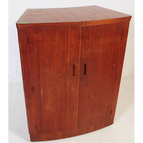 679 - British Modern Design - A mid 20th century teak drinks / cocktail cabinet. Twin front doors with fla... 