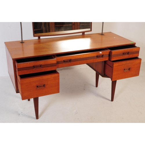 683 - British Modern Design - Mid 20th century teak dressing table. Rectangular form with knee hole to cen... 