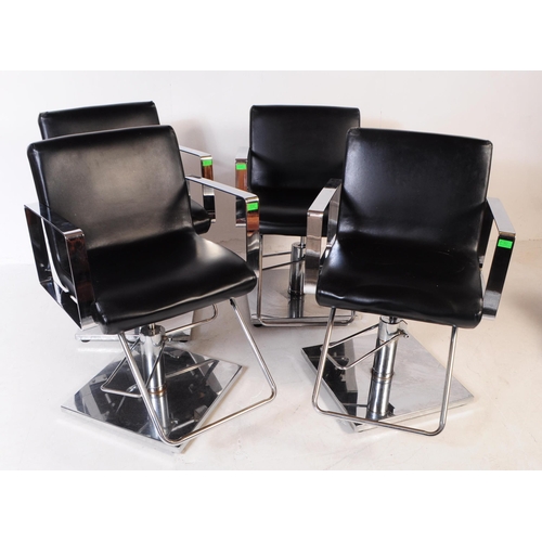 702 - Four contemporary salon barber chairs / adjustable armchairs. The chairs upholstered in black vinyl ... 