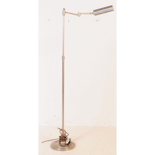 710 - A 20th century chrome floor standing standard lamp with machinist style shade. The lamp featuring a ... 