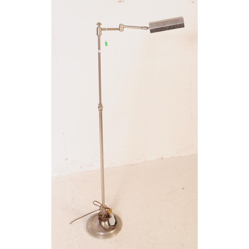 710 - A 20th century chrome floor standing standard lamp with machinist style shade. The lamp featuring a ... 