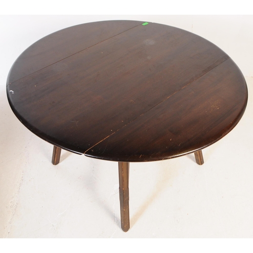 714 - Ercol - Mid 20th century dark elm dining table. Rectangular form with drop leaves, angled supports u... 