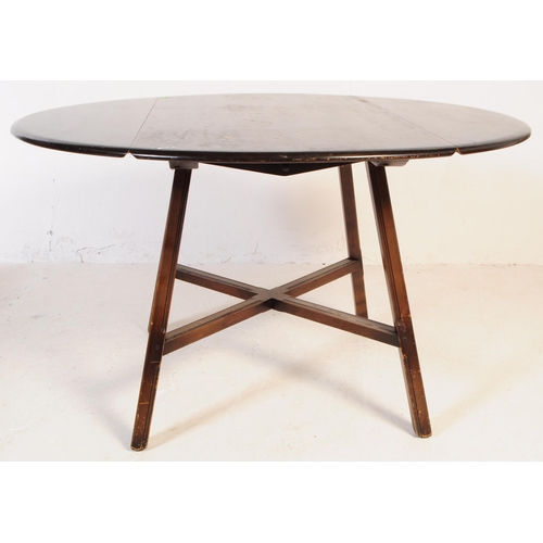 714 - Ercol - Mid 20th century dark elm dining table. Rectangular form with drop leaves, angled supports u... 