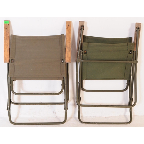 728 - A pair of mid 20th century metal and canvas folding military chairs. The chairs having bent painted ... 