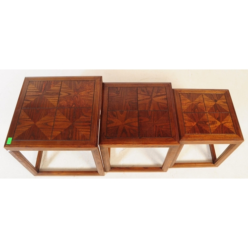 738 - G-Plan - A mid 20th century G Plan oak nest of side tables. The tables each of square form with beve... 