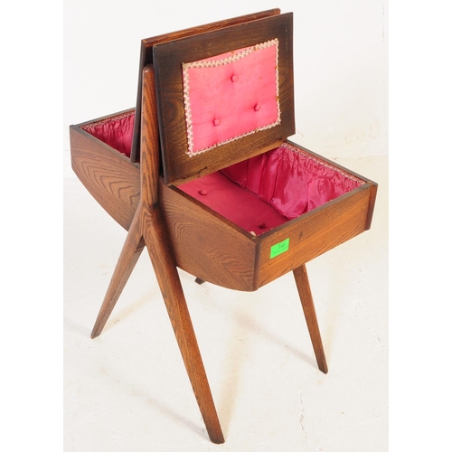 740 - A mid 20th century teak wood sewing box. The sewing box raised on tapered wood legs, with a handle t... 