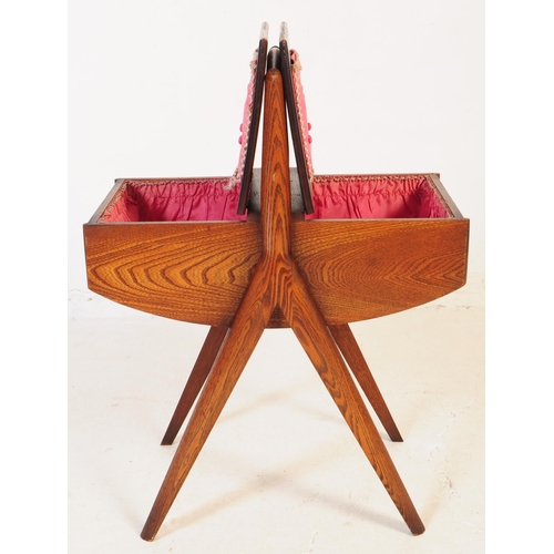 740 - A mid 20th century teak wood sewing box. The sewing box raised on tapered wood legs, with a handle t... 