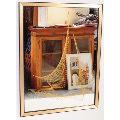 741 - A mid 20th century circa 1970s framed wall mirror. The mirror of rectangular form with gilt panellin... 