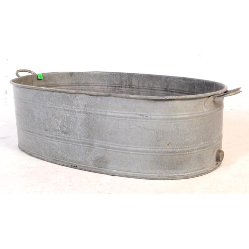 769 - An early 20th century large oval galvanised tin bath. Of oval form, with handles to either side and ... 