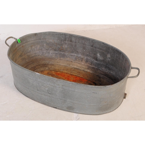 769 - An early 20th century large oval galvanised tin bath. Of oval form, with handles to either side and ... 