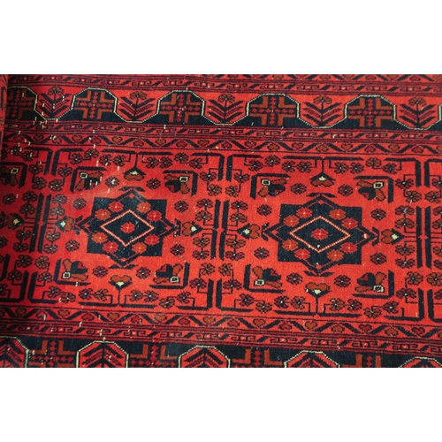 774 - A 20th century Khan Mohammadi manner Afghan carpet floor runner rug. The rug having a red ground, wi... 