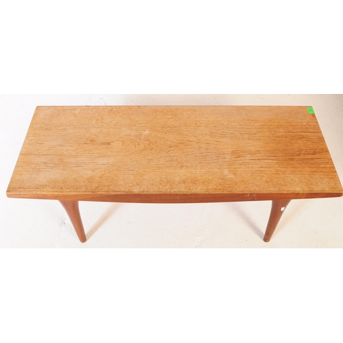 556 - A mid 20th century teak wood coffee table. The table of rectangular form, with shaped angled side, r... 