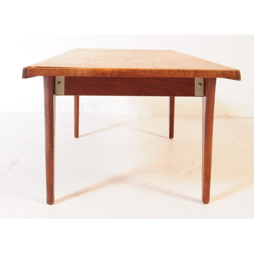 556 - A mid 20th century teak wood coffee table. The table of rectangular form, with shaped angled side, r... 