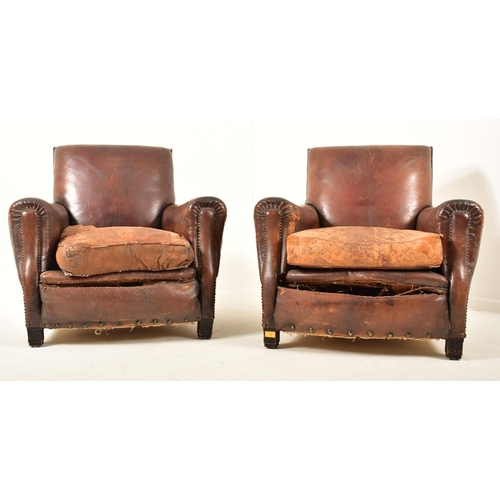 12 - A matching pair of early 20th century Art Deco well weathered leather club armchairs / fireside chai... 