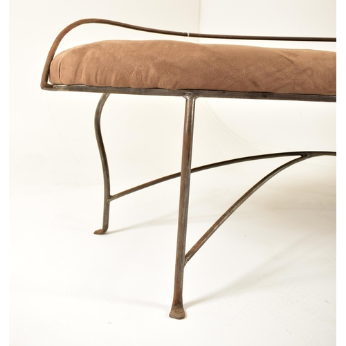 132 - A contemporary wrought iron lover bench / seat. Oval padded seat rest with brown suede upholstery an... 