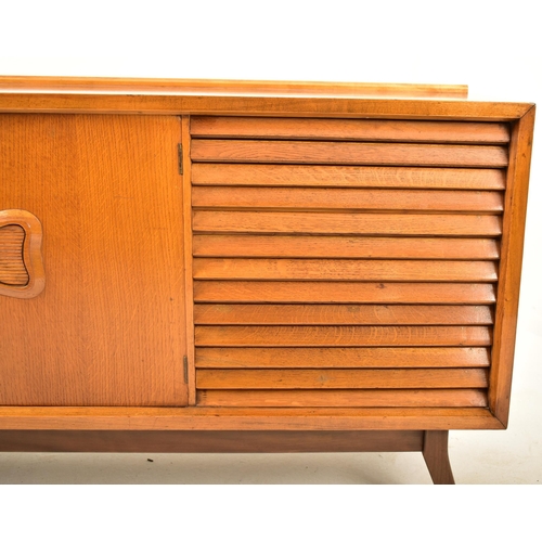 145 - A retro mid 20th century teak and walnut sideboard credenza. The sideboard having a double door cupb... 