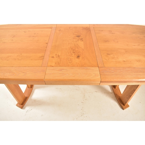 147 - A contemporary high end British design modern oak extending dining table. The table having a deep ch... 