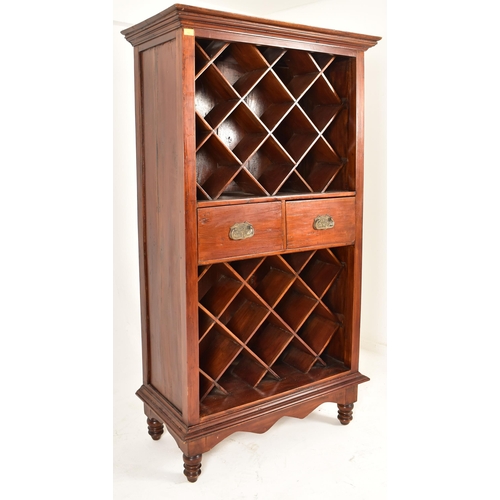 166 - A vintage 20th century hardwood wine cabinet on feet. The cabinet having a flared pediment atop over... 