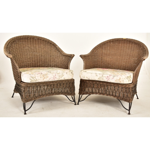 168 - A pair of retro 20th century wirework frame and wicker garden outdoor armchairs. Each chair having a... 