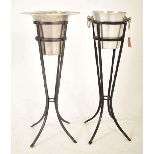 176 - Two retro 20th century aluminum champagne ice buckets. Each in a twisted cast iron stand with one ic... 