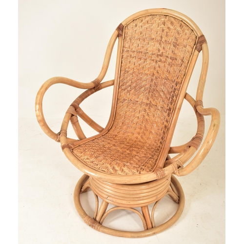 202 - A retro 20th century bamboo and wicker / cane swivel armchair / egg chair. The chair having a curved... 