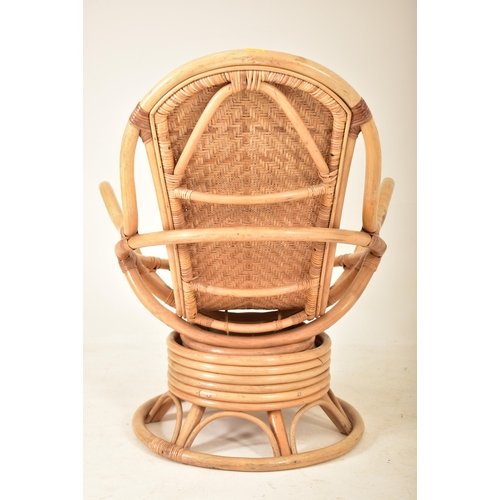 202 - A retro 20th century bamboo and wicker / cane swivel armchair / egg chair. The chair having a curved... 