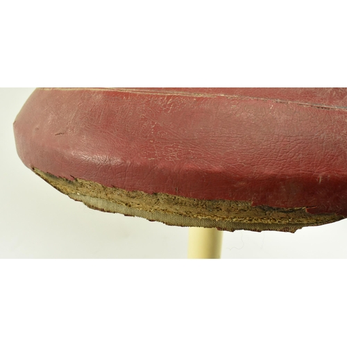 214 - A retro 20th century leather upholstered & metal Tulip manner stool. The stool having a circular pad... 