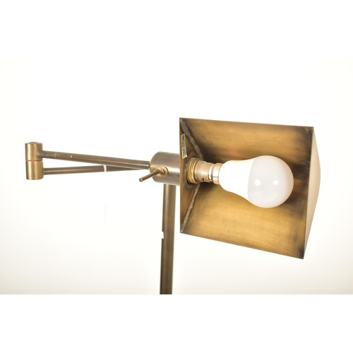 271 - A retro 20th century 1960s inspired brassed metal floor standard lamp. The lamp having a shaped shad... 