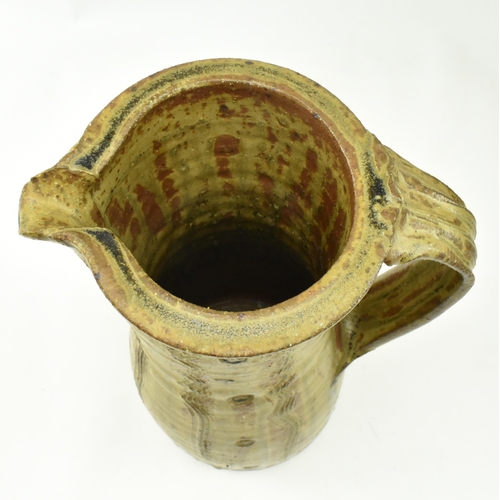 273 - Jim Malone (b. 1946) - A large studio art pottery stoneware single handled jug. The jug having textu... 