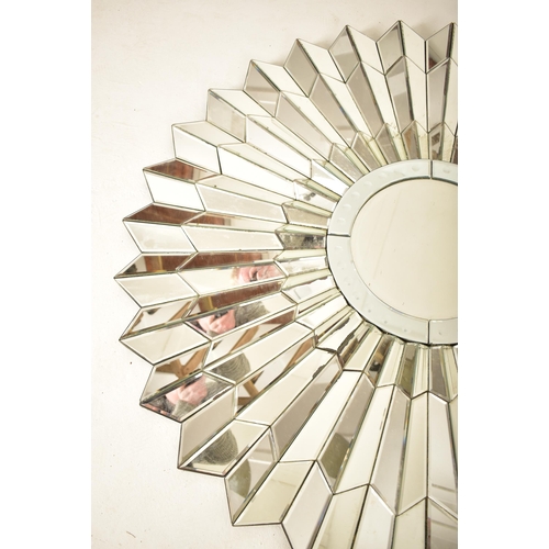 37 - A vintage late 20th century Art Deco influenced designer hanging mirror of starburst form. Central m... 