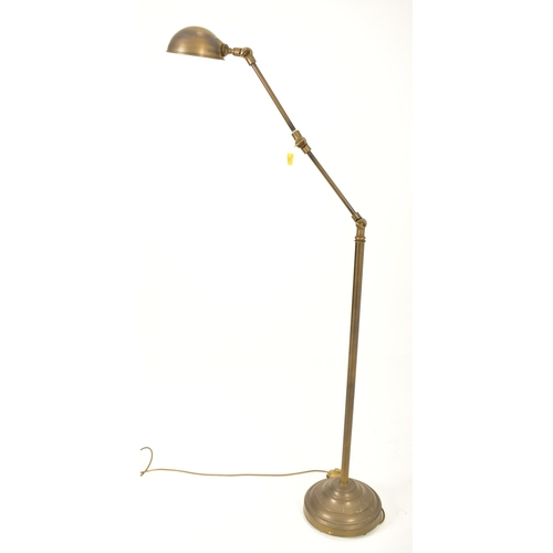 424 - A retro 20th century brassed metal industrial manner floor standard lamp. The light having a dome sh... 