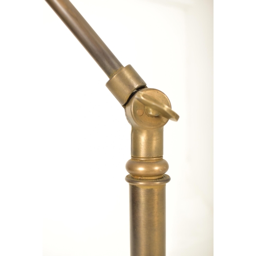 424 - A retro 20th century brassed metal industrial manner floor standard lamp. The light having a dome sh... 