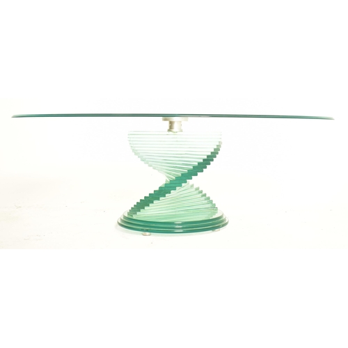 75 - A high-end design contemporary glass spiral coffee low occasional table. The table having an oval te... 