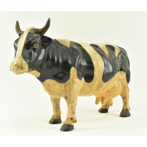 79 - A large contemporary heavy cast iron model of a cow. The door stop cow standing with painted feature... 