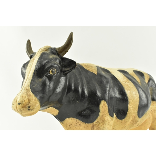 79 - A large contemporary heavy cast iron model of a cow. The door stop cow standing with painted feature... 