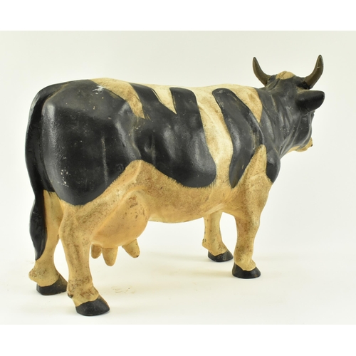 79 - A large contemporary heavy cast iron model of a cow. The door stop cow standing with painted feature... 