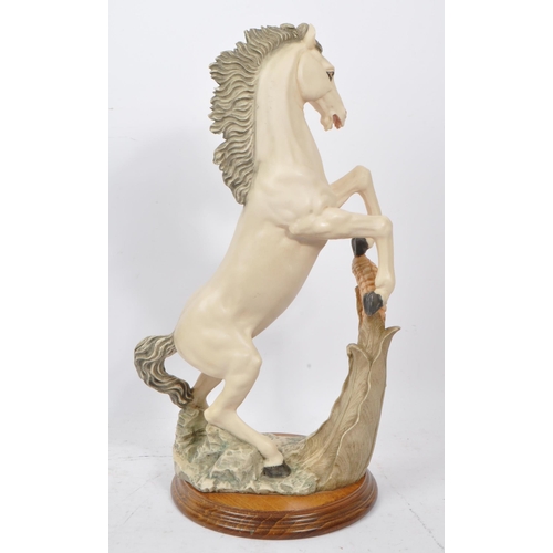 112 - A large resin 20th Century figure of a rearing white horse with a corn to the forefront. The horse s... 