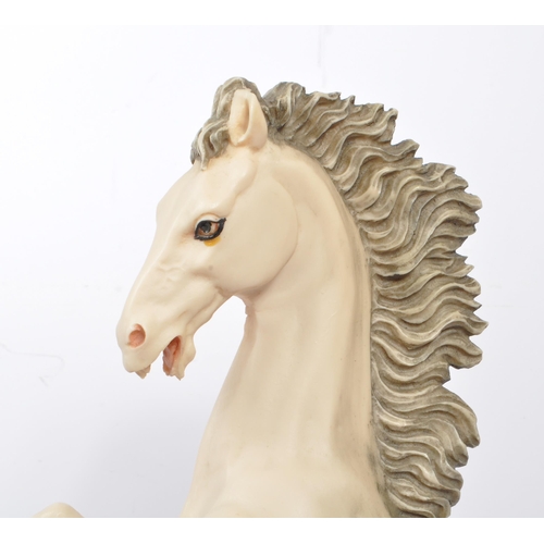 112 - A large resin 20th Century figure of a rearing white horse with a corn to the forefront. The horse s... 