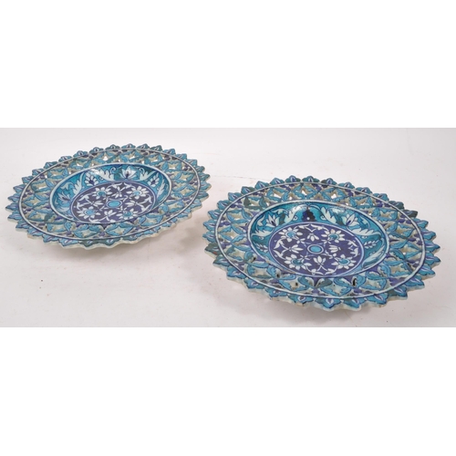 124 - A pair of ceramic earthenware tin glazed Islamic pierced chargers / wall plates in vibrant blue grou... 