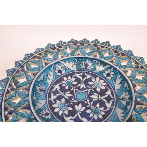 124 - A pair of ceramic earthenware tin glazed Islamic pierced chargers / wall plates in vibrant blue grou... 