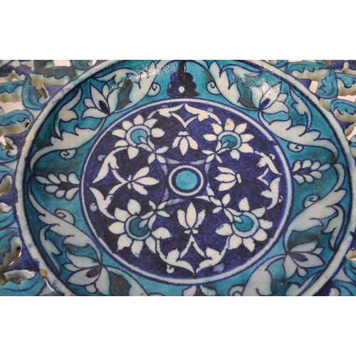 124 - A pair of ceramic earthenware tin glazed Islamic pierced chargers / wall plates in vibrant blue grou... 