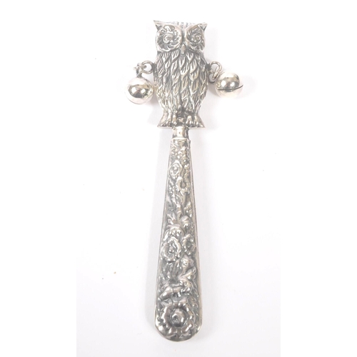 194 - A vintage 20th century silver babies rattle. With owl figure to top, with loose metal balls on taper... 