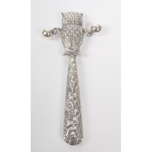 194 - A vintage 20th century silver babies rattle. With owl figure to top, with loose metal balls on taper... 