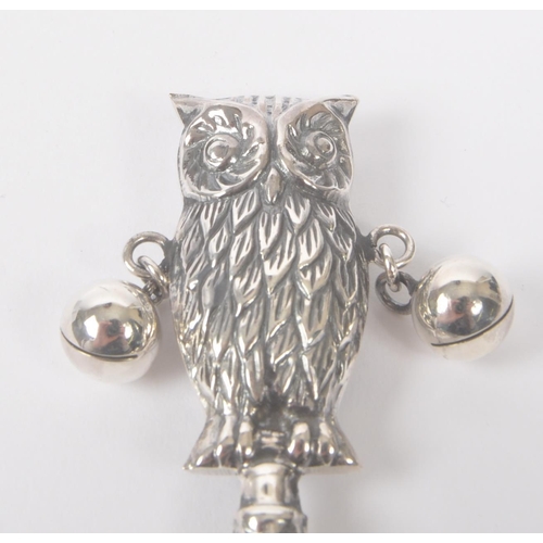 194 - A vintage 20th century silver babies rattle. With owl figure to top, with loose metal balls on taper... 