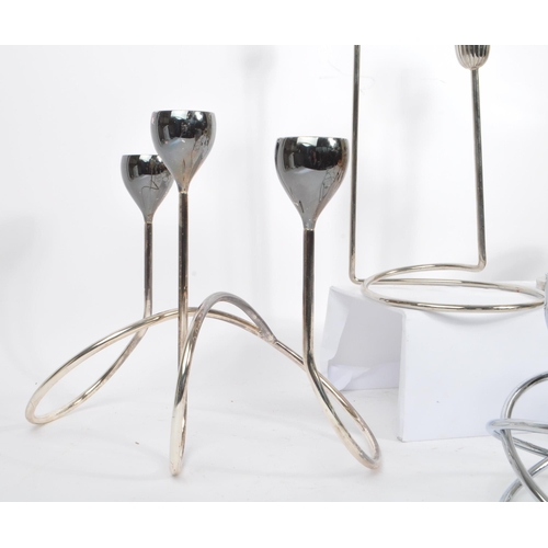 202 - A collection of 1980s and later late 20th century stainless steel candle holders. The lot to include... 