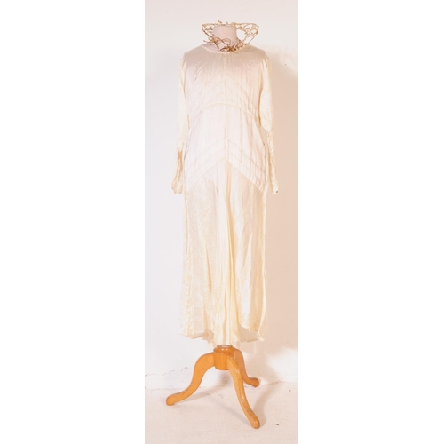 211 - An early 20th Century 1920s vintage ivory coloured silk wedding dress, comprising of both under and ... 