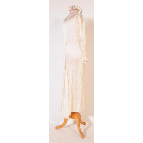 211 - An early 20th Century 1920s vintage ivory coloured silk wedding dress, comprising of both under and ... 