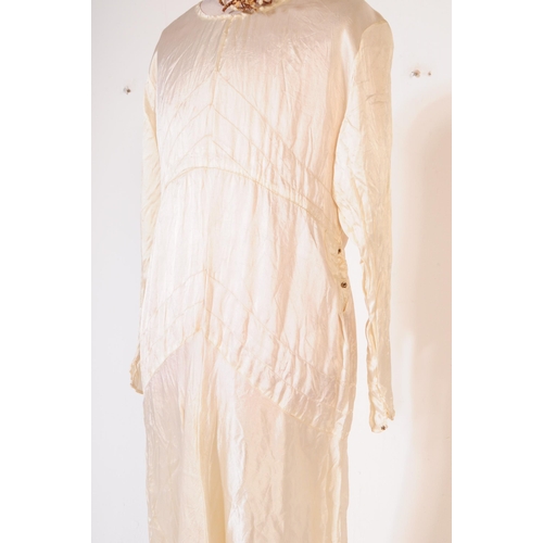 211 - An early 20th Century 1920s vintage ivory coloured silk wedding dress, comprising of both under and ... 